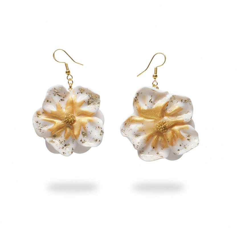 Ces boucles d'oreilles présentent un motif floral raffiné en blanc immaculé, rehaussé de touches dorées pour une touche de sophistication. L'argile polymère utilisée garantit une légèreté exceptionnelle tout en offrant une résistance durable