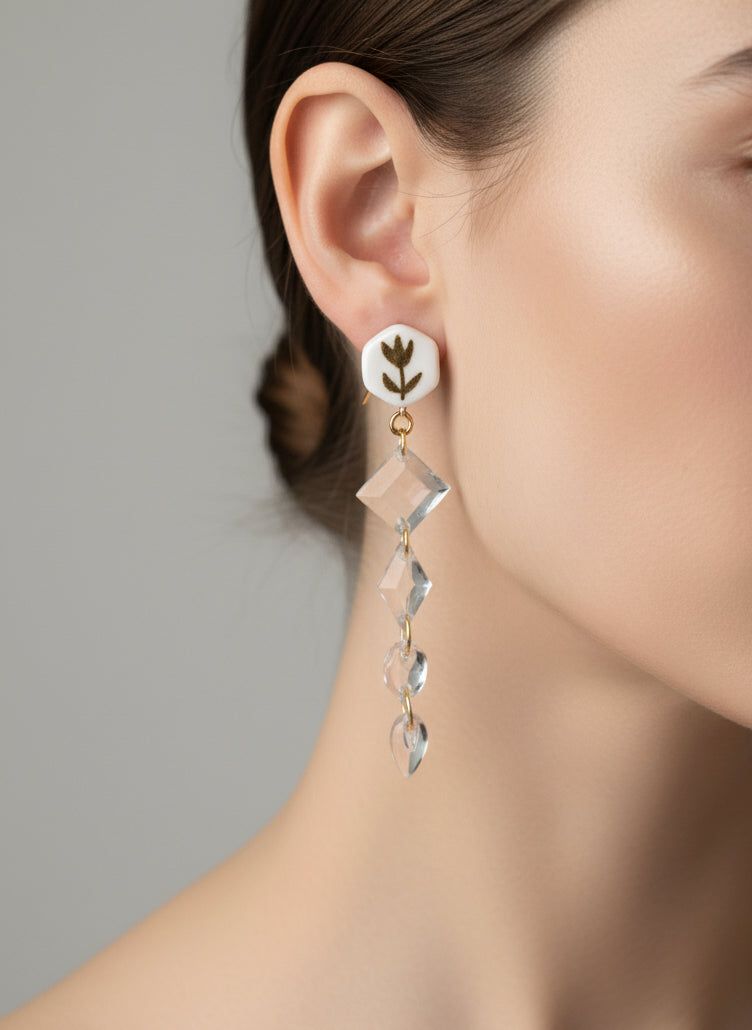 Boucles d'oreilles florales or et blanc avec pendentifs en cristal transparent et crochet doré en acier inoxydable, style chic et rétro. Bijou fait main idéal pour une soirée élégante ou un look vintage raffiné.