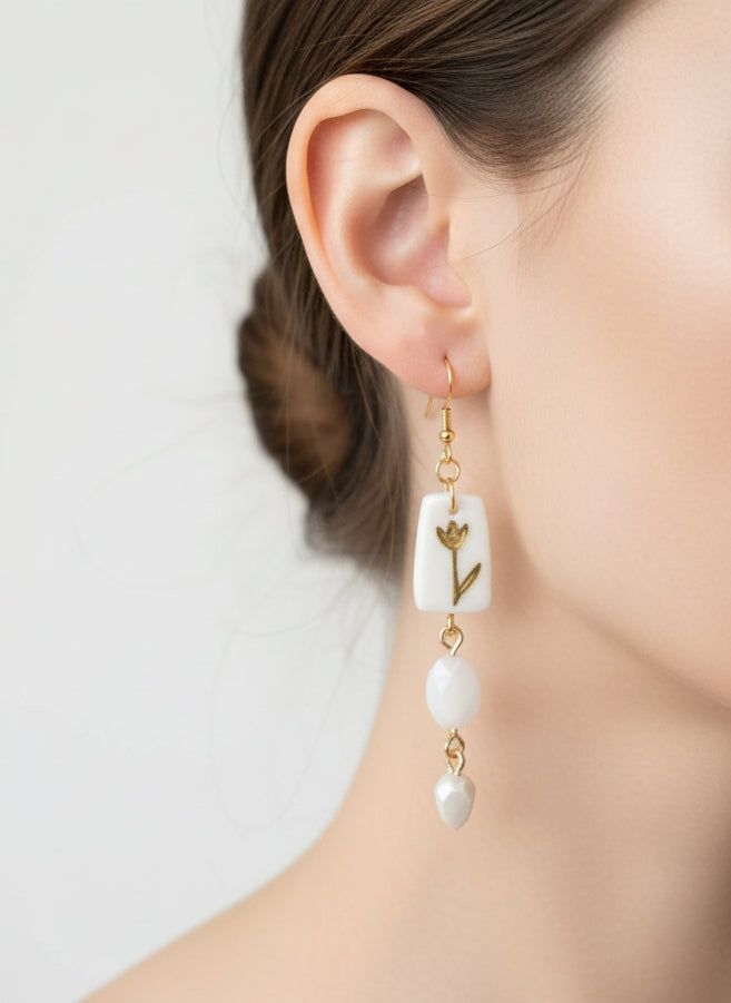 Boucles d'oreilles retro or et blanches avec pendentif floral peint à la main en argile et perles en résine. Design chic et vintage de 9 cm.